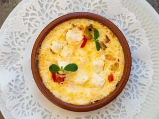 Flan de legumes et feta. Rustic pie with vegetables and cheese served on clay pot on table