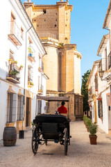Carriage with tourists next to the Church of Santa Maria la Mayor in the historic center of Ronda, Malaga