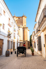 Fototapeta na wymiar Carriage with tourists next to the Church of Santa Maria la Mayor in the historic center of Ronda, Malaga