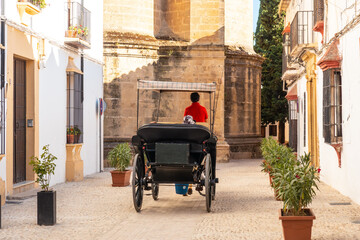 Fototapeta na wymiar Carriage with tourists next to the Church of Santa Maria la Mayor in the historic center of Ronda, Malaga