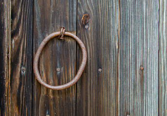 A rustic old pull handle on a wooden door
