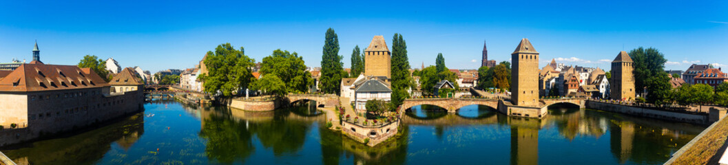 Picturesque panoramic view of Strasbourg cityscape overlooking Ponts Couverts with four towers seen from viewing terrace of Barrage Vauban on sunny summer day, France - obrazy, fototapety, plakaty