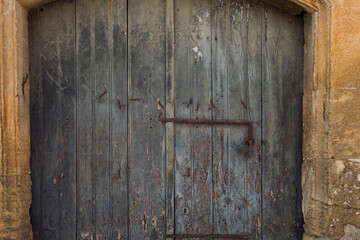 Old wooden door with a rusty lock. Close-up. Front view.