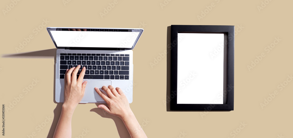 Poster laptop computer with a blank photo frame - flat lay