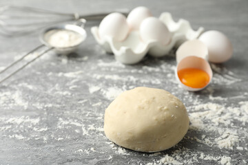 Wheat dough and products on grey table, space for text. Cooking pastries