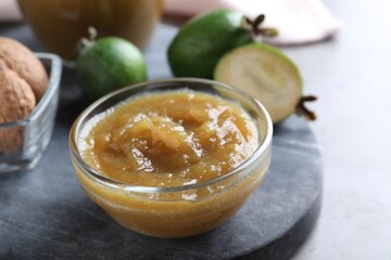 Feijoa jam in glass bowl on grey table, closeup