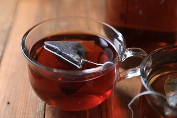 Tea bag in cup on wooden table, closeup