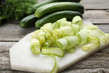Slices of fresh ripe cucumbers on wooden table, closeup