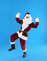 Full length portrait of Santa Claus on light blue background