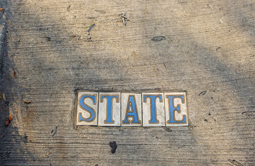 Traditional State Street Tile Inlay Street Sign on Sidewalk in Uptown Neighborhood in New Orleans,...