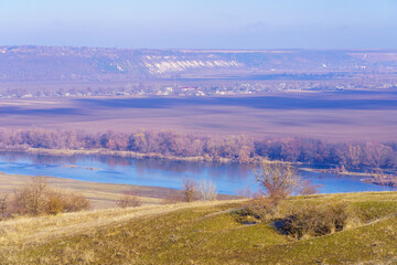 Beautiful view of the hilly valley with the river soothing winter nature. Background with copy space