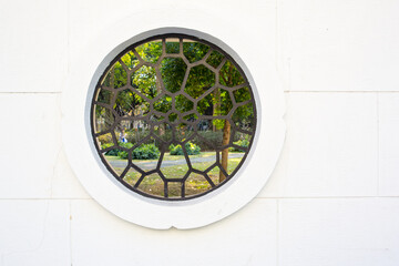 Fototapeta na wymiar View through a round window in a wall