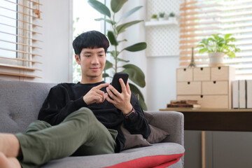 Happy young man checking social media or shopping online on smart phone.