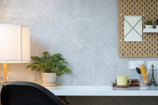 Modern workplace with stationery, coffee cup, houseplant and lamp. Copy space for your text.