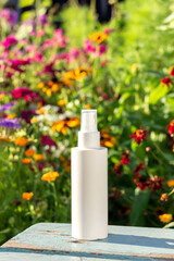 White blank cosmetic spray bottle on bright floral background. Natural Organic Spa Cosmetic Beauty Concept Mockup Front view