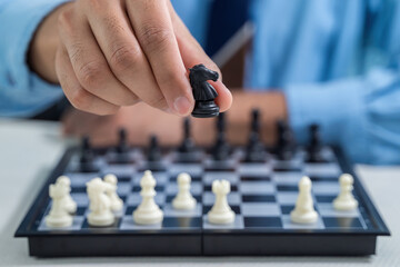 Man's hand holding chess horse figure in competition success play. strategy, teamwork, management, leadership, team and success concept.
