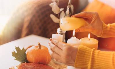 Autumn interior and festive mood with burning candles and pumpkin.