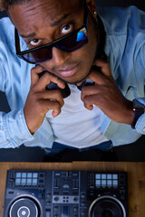 Stylish dark-skinned man with an earring in his ear in sunglasses and a smart watch close up posing...