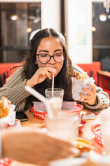 Woman drinking milkshake and eat tacos in a restaurant