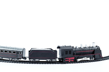 A closeup of a black toy train on a white background