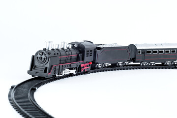 A closeup of a black toy train on a white background