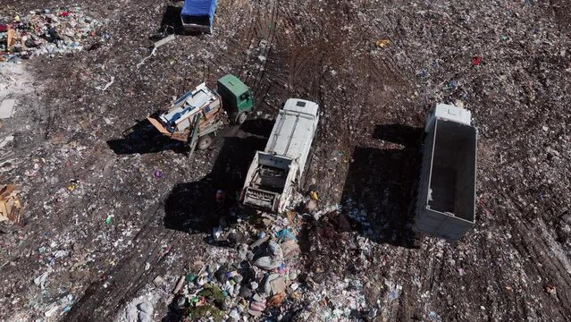 Landfill with solid household waste. Garbage truck unloads rubbish. Garbage dump with waste plastic and polyethylene. Solid waste disposal and landfill gas collection. Environmental pollution.