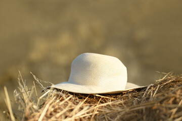 The straw hat lying on a haystack.  Summer headdress. Harvest concept