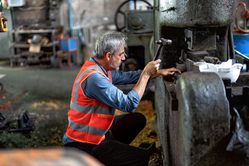 In maintenance workshop senior engineer fixing malfunction hydraulic compress machine stem 
