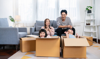 Fototapeta na wymiar Asian family father mother daughter girl packing cardboard box moving, online marketing e-commerce unpacking stuff belongings home delivery. Lifestyle happy white family together relocation