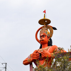 Big statue of Lord Hanuman near the delhi metro bridge situated near Karol Bagh, Delhi, India, Lord Hanuman statue touching sky - obrazy, fototapety, plakaty