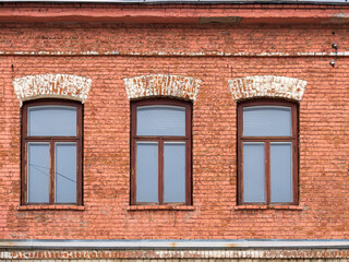 Three windows of the old mansion 19 century with brown bricks wall