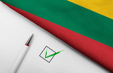 Pencil, Flag of Lithuania and check mark on paper sheet
