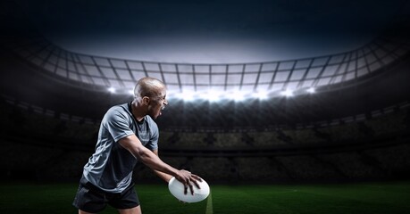 Composition of male rugby player holding rugby ball over sports stadium