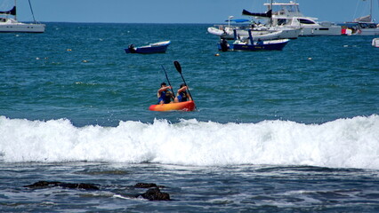 Fototapeta premium Kayaker in the water, off the beach, in Tamarindo, Costa Rica