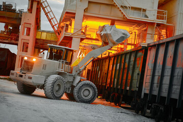 Wheeled loader loads wagon with lime powder at lime plant