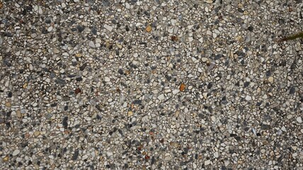 Small black and brown pebbles on the ground walking.