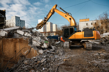 Obraz premium Excavator with hydraulic scissors cuts concrete beams