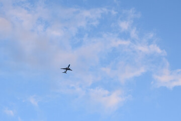 Fototapeta na wymiar avion comercial de pasajeros con cielo con nubes al atardecer,, concepto de vacaciones y viajes