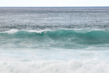 Fototapeta na wymiar Small Ocean Wave Breaking onto the Shore