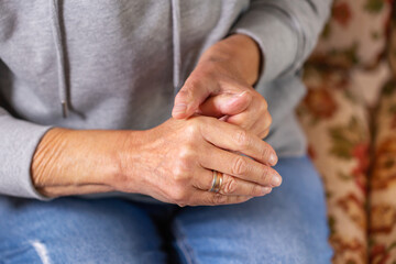 Senior woman suffering from hand and finger joint pain, inflammation