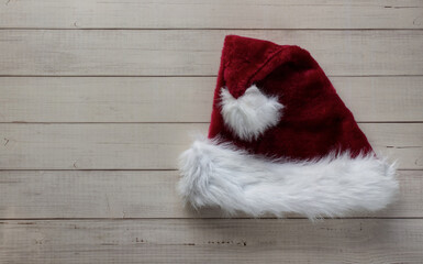 Obraz na płótnie Canvas Red Santa Claus hat isolated on wooden background. Christmas decoration. Christmas ornaments. Flat lay.