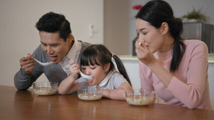 Obraz na płótnie Canvas Family concept of 4k Resolution. Asian parents and children eating together in the house.