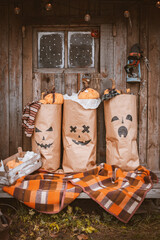 Photo zone for Halloween with festive handmade paraphernalia. Kraft paper bags painted with Jack pumpkin grimace, monsters decorations for Halloween