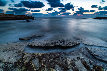 water flowing around rock textures in the beach Habonim Israel