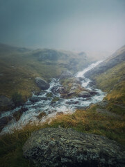 Mountain stream flowing fast across a rocky valley in Fagaras Mountains. River with high water...