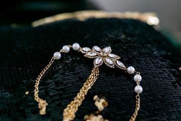 Indian bride's wedding jewellery with pearls on black shiny surface close up