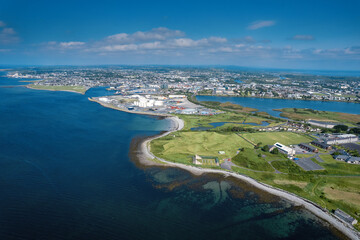Aerial view on Galway city, Ireland on a warm sunny day. Blue cloudy sky and water of the ocean. Popular tourist town, business hub and educational center with rich history.