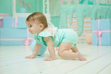A little girl under the age of 1 year crawling in the nursery