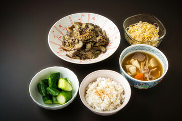 和風朝食イメージ、黒背景の白い皿に盛られた和風料理