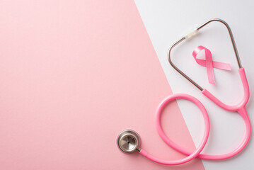 Fototapeta premium Breast cancer awareness concept. Top view photo of pink silk ribbon and stethoscope on bicolor pastel pink and white background with copyspace